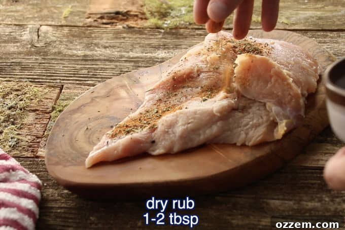 Hunter's Smoked Wild Turkey Breast 8 A close-up view of a wild turkey breast being generously seasoned with a dry rub, with hands sprinkling the spices to ensure an even and flavorful coating before smoking.