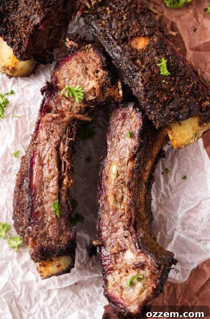 A beautifully smoked rack of beef ribs adorned with a savory dry rub, glistening and ready to be carved.