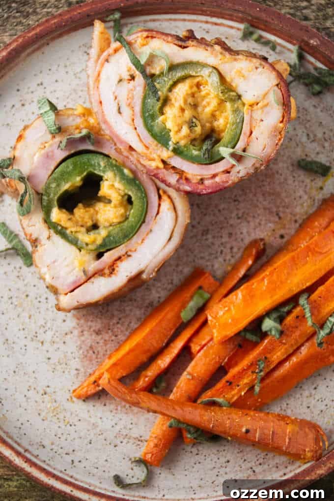 Jalapeño popper stuffed chicken breast sliced and plated with some air fryer carrots.