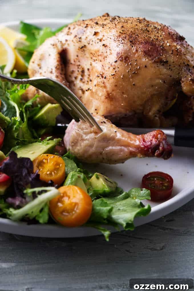 Perfectly Smoked Traeger Cornish Game Hens 6 A beautifully smoked Cornish game hen served on a plate with a fresh side salad, highlighting the golden skin.