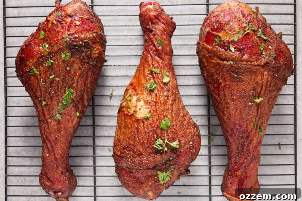 Disney's Iconic Smoked Turkey Legs 5 Three smoked turkey legs laying on a metal wire rack to rest