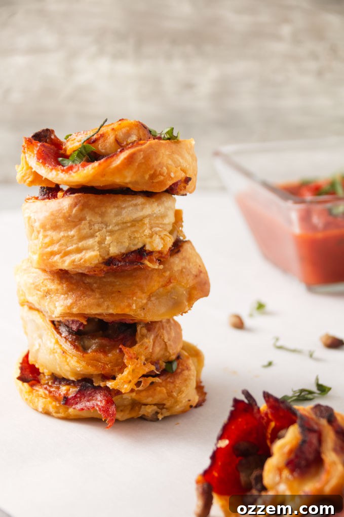 Crispy Homemade Air Fryer Pizza Rolls 6 Crispy air fryer pizza rolls in a stack with pizza sauce for dipping.