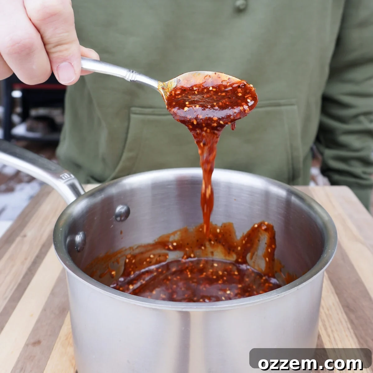 Crispy Bacon Chicken Legs 9 Chili Crunch Honey BBQ Sauce simmering in a saucepan.
