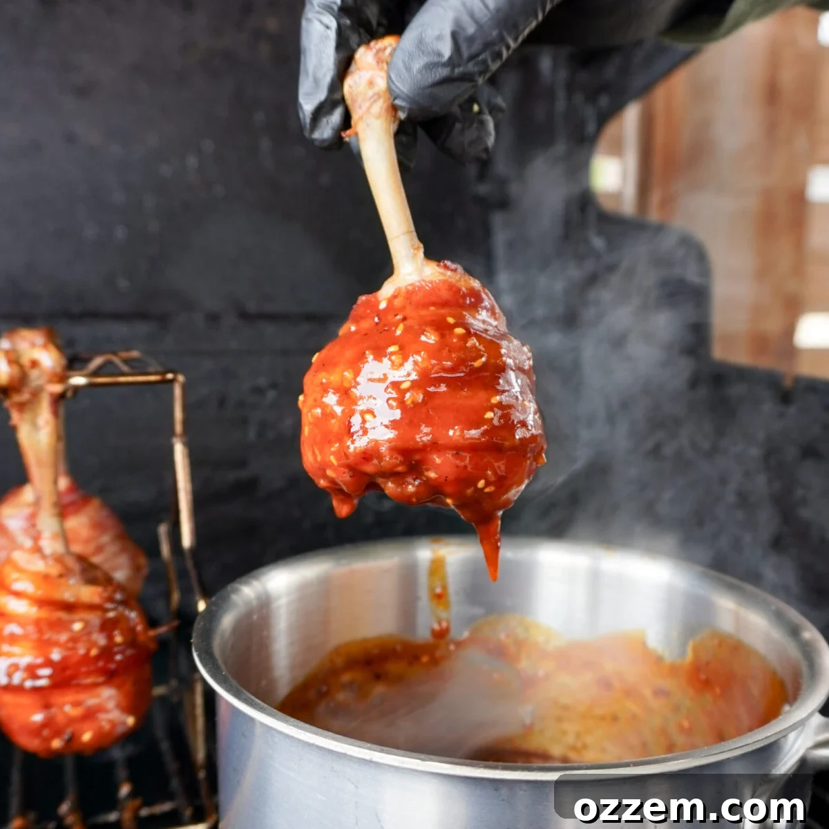 Crispy Bacon Chicken Legs 10 Dunking the bacon wrapped chicken drumsticks into the chili crunch honey BBQ sauce.