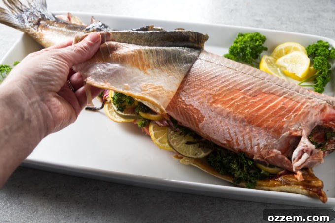 Grilled Whole Salmon Made Simple 11 Removing the skin from a cooked salmon.