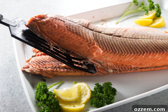 Grilled Whole Salmon Made Simple 12 A whole cooked salmon being carved and de-boned.
