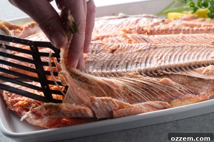 Grilled Whole Salmon Made Simple 14 Removing the spine and bones after cooking a whole salmon.