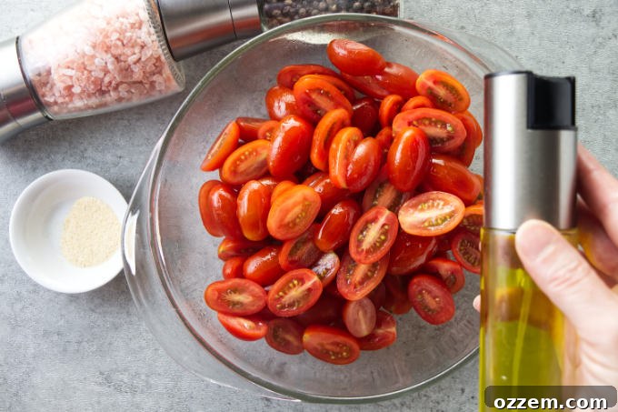 Tossing cherry tomatoes with oil and seasoning.
