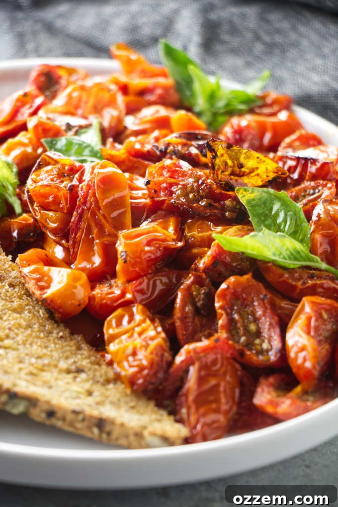 Air fryer cherry tomatoes on a plate with basil garnish.