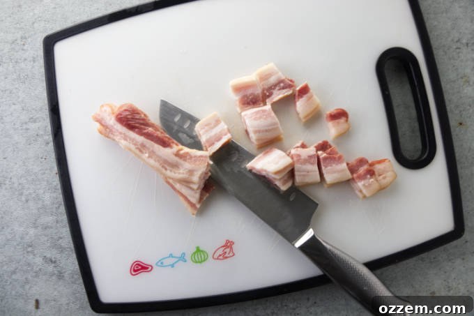 Chopping raw bacon into small pieces for the air fryer green beans recipe.
