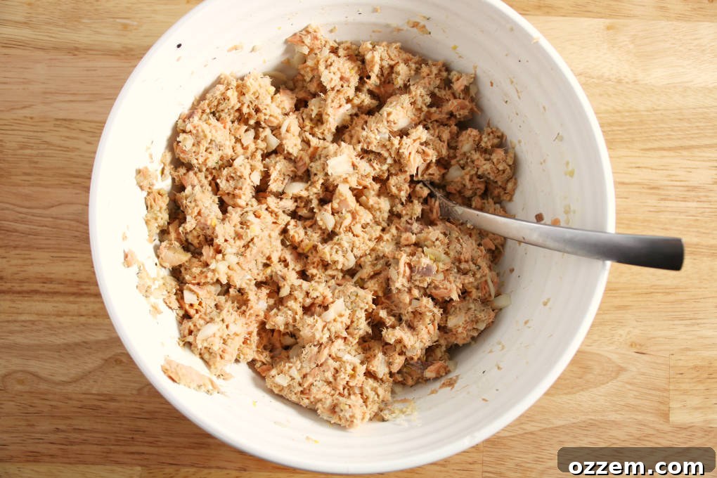 A close-up of the thoroughly mixed ingredients for air fryer salmon cakes in a bowl, showing the cohesive texture before forming patties.