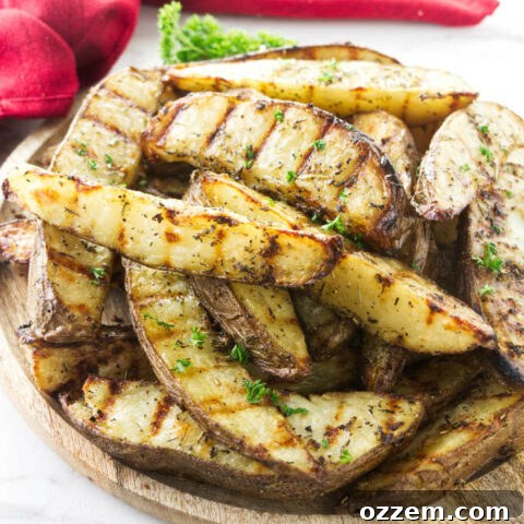 A serving platter with grilled potato wedges garnished with fresh herbs.
