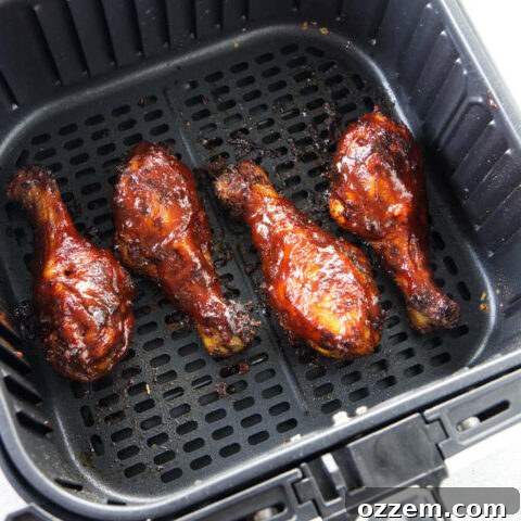 BBQ chicken legs in an air fryer basket.