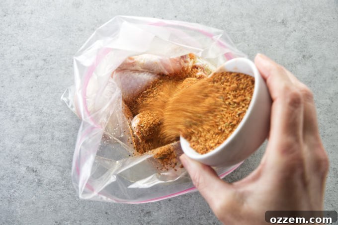 Pouring bbq dry rub seasoning over chicken drumsticks.