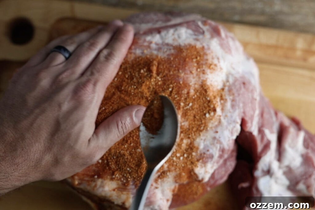 Rubbing pork butt with dry pork butt rub.