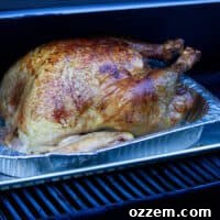 A Smoked turkey on the grill in a Traeger, ready for carving.