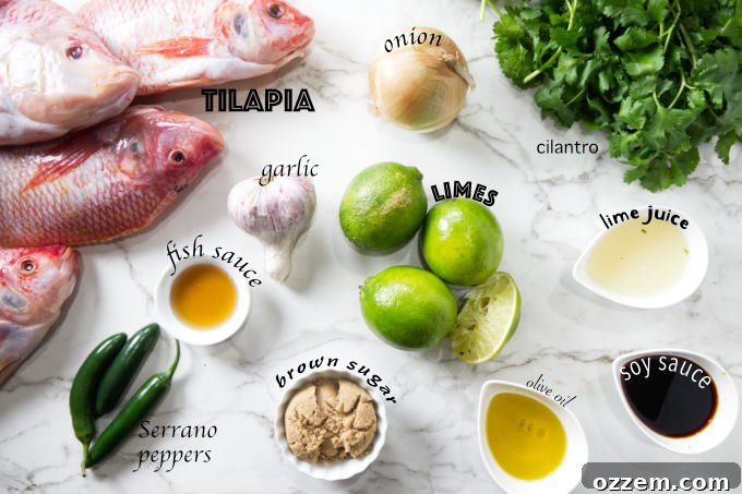 A vibrant collection of fresh ingredients laid out, including whole tilapia, limes, onions, garlic, cilantro, and chili peppers, ready for grilling on a pellet smoker.