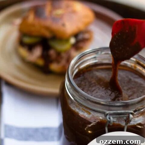 pumpkin spice bbq sauce dripping from utensil and pulled pork sandwich in background
