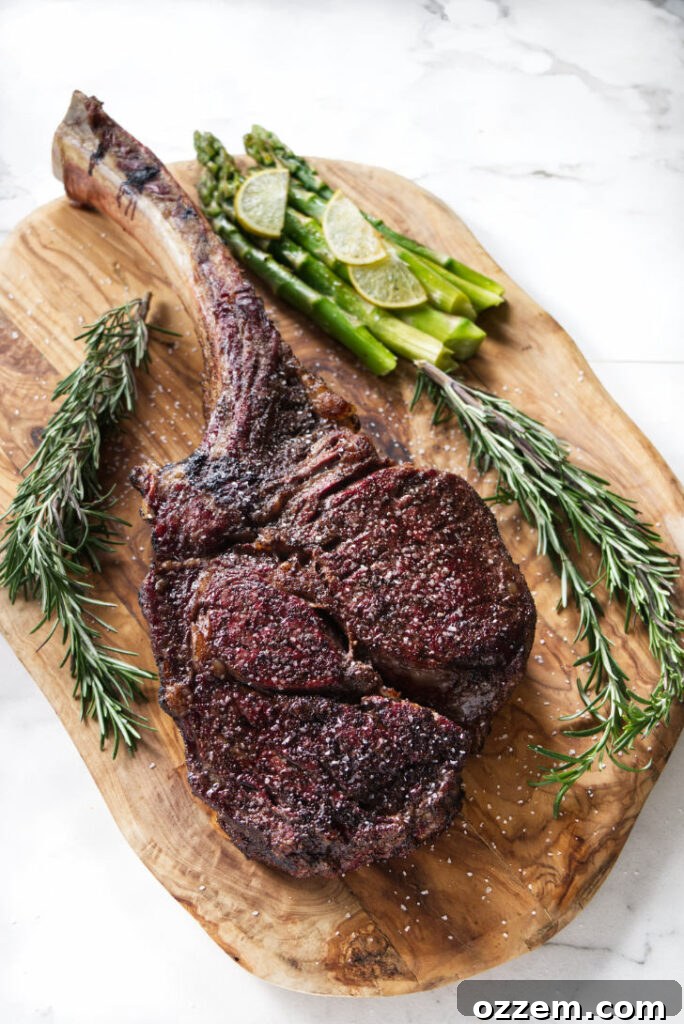 Expertly reverse seared tomahawk ribeye steak, bone-in and perfectly crusted, ready for carving.