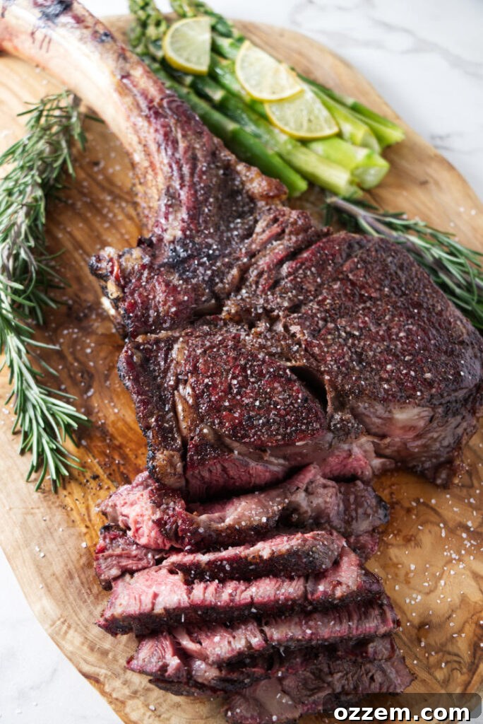 Slicing a perfectly cooked reverse seared tomahawk steak, revealing its juicy, medium-rare interior.