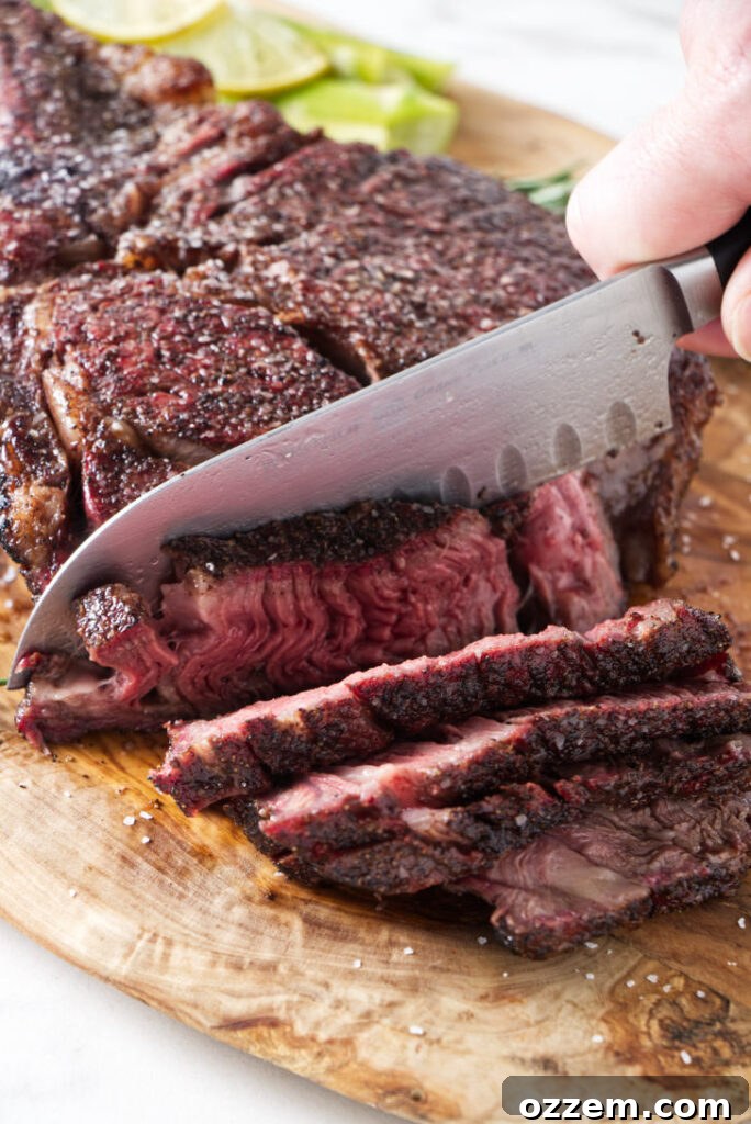 Carved slices of a perfectly reverse seared tomahawk ribeye steak, showcasing its juicy interior and crispy crust.