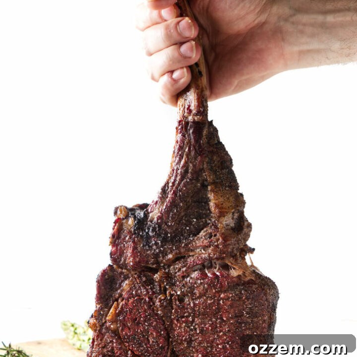 Perfectly reverse seared Traeger tomahawk steak, showcasing its impressive bone and crust, resting on a cutting board.