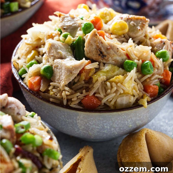 A bowl of Blackstone chicken fried rice next to some fortune cookies.