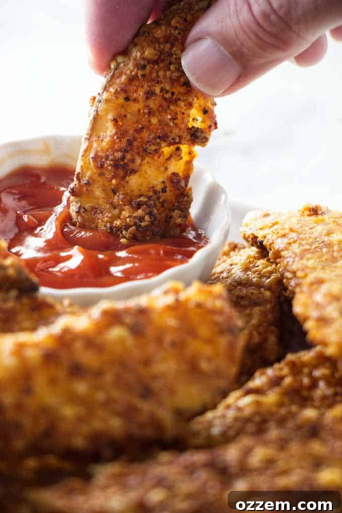 Crispy Cheesy Air Fryer Potato Wedges 3 Air Fryer potato wedge being dipped in ketchup