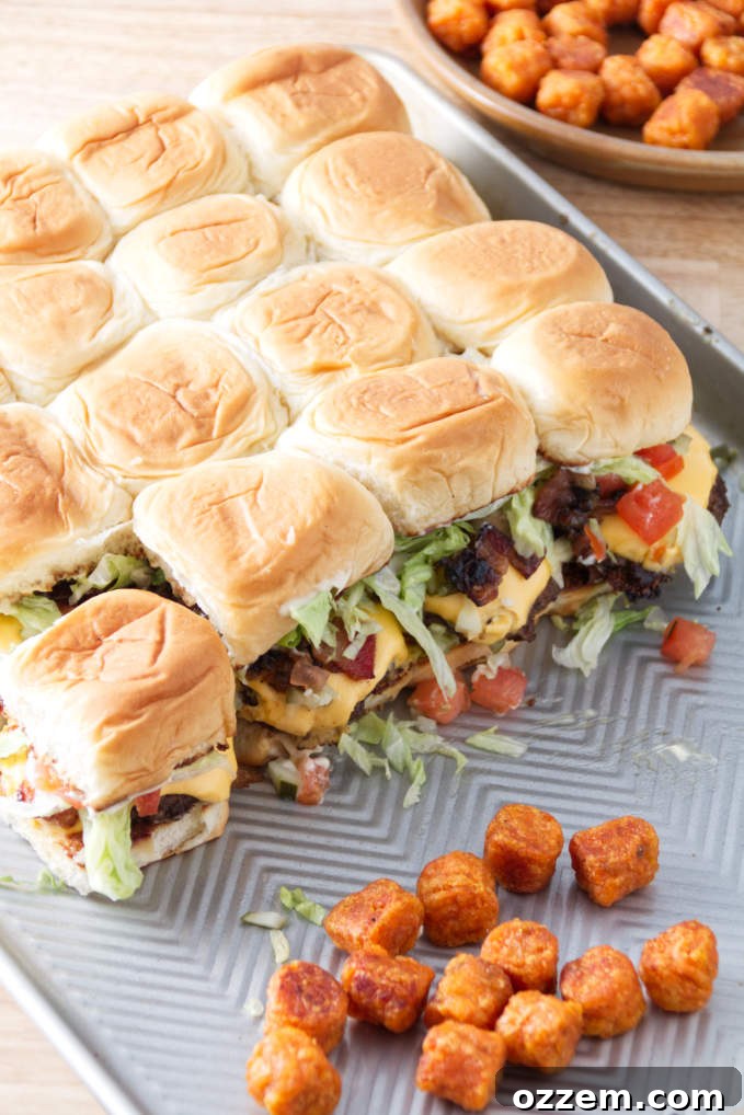 smashburger sliders assembled on a sheet pan with tater tots.