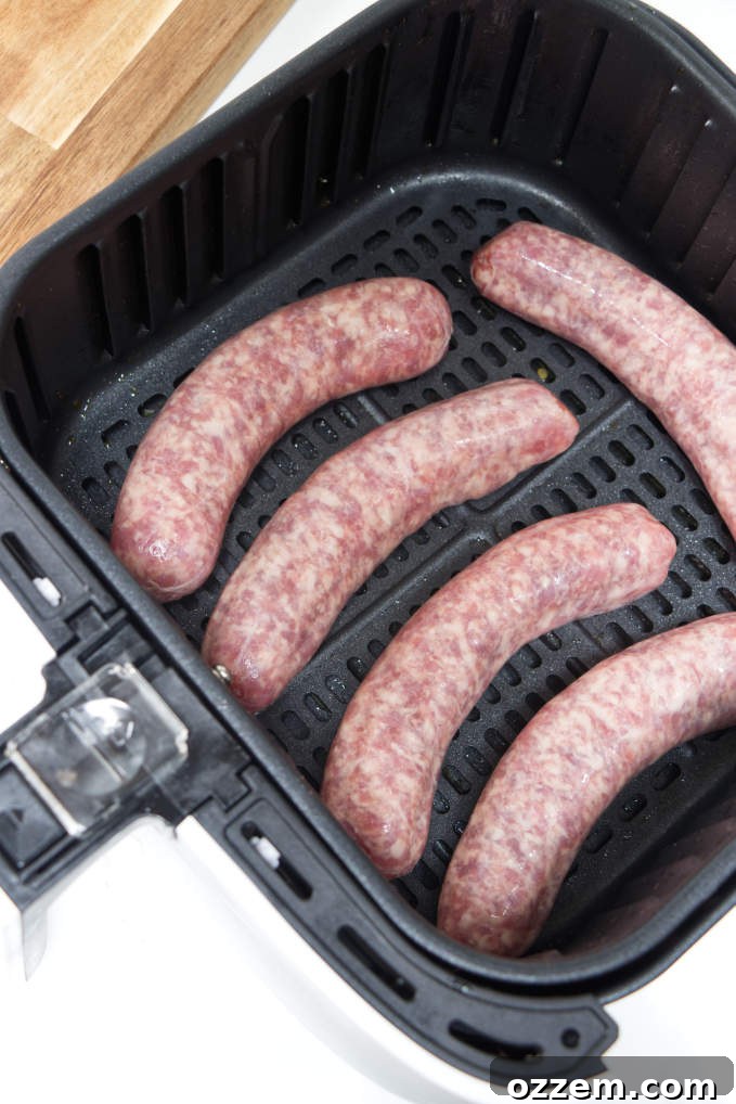 Perfect Air Fryer Brat Sandwiches 4 Five uncooked brats in an air fryer basket.
