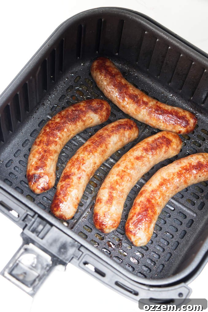 Perfect Air Fryer Brat Sandwiches 5 Freshly cooked air fryer brats in an air fryer basket.