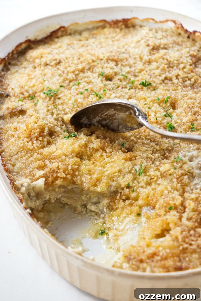 A golden brown casserole dish brimming with creamy, cheesy au gratin potatoes, fresh out of the smoker.