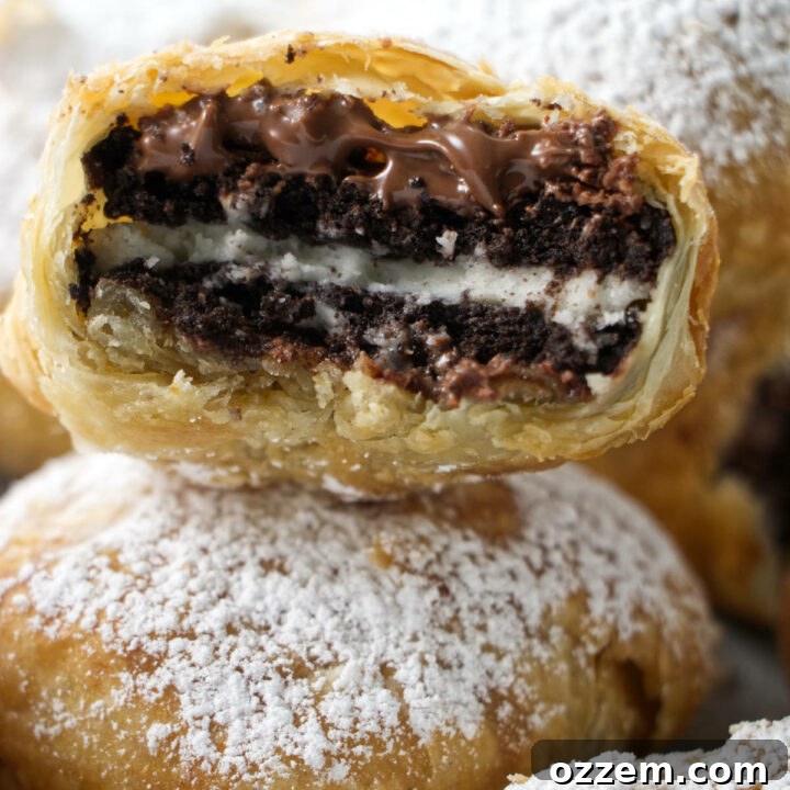 stack of air fried oreos with one in the middle that has been bitten into with nutella oozing out and a crumbly puff pastry shell.