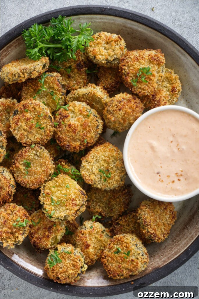Air fried pickles on a platter with dipping sauce.