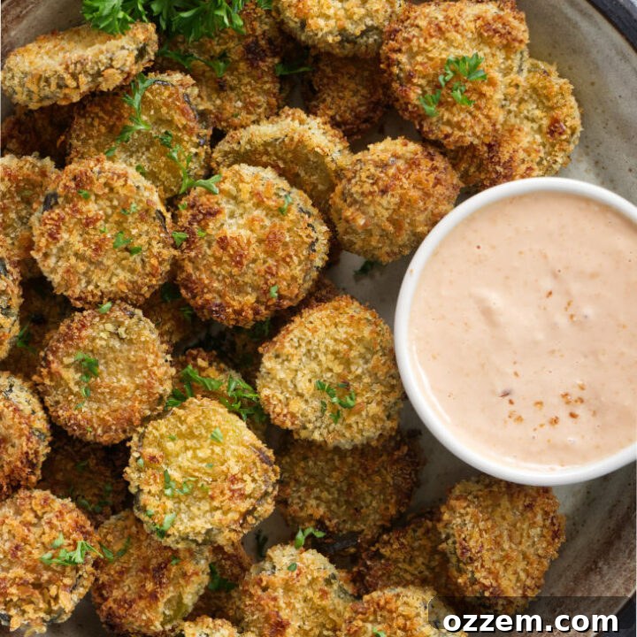 Air fried pickles on a platter with dipping sauce.