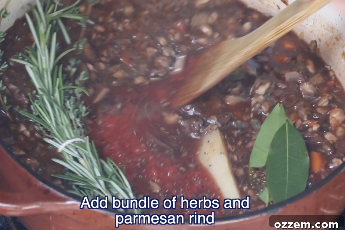 adding herbs and parmesan rind to ragu