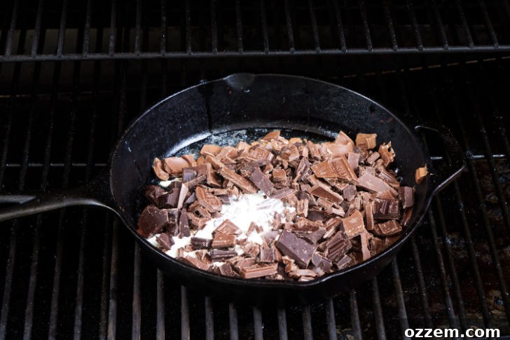 Melting chocolate and cream in a skillet on a grill.