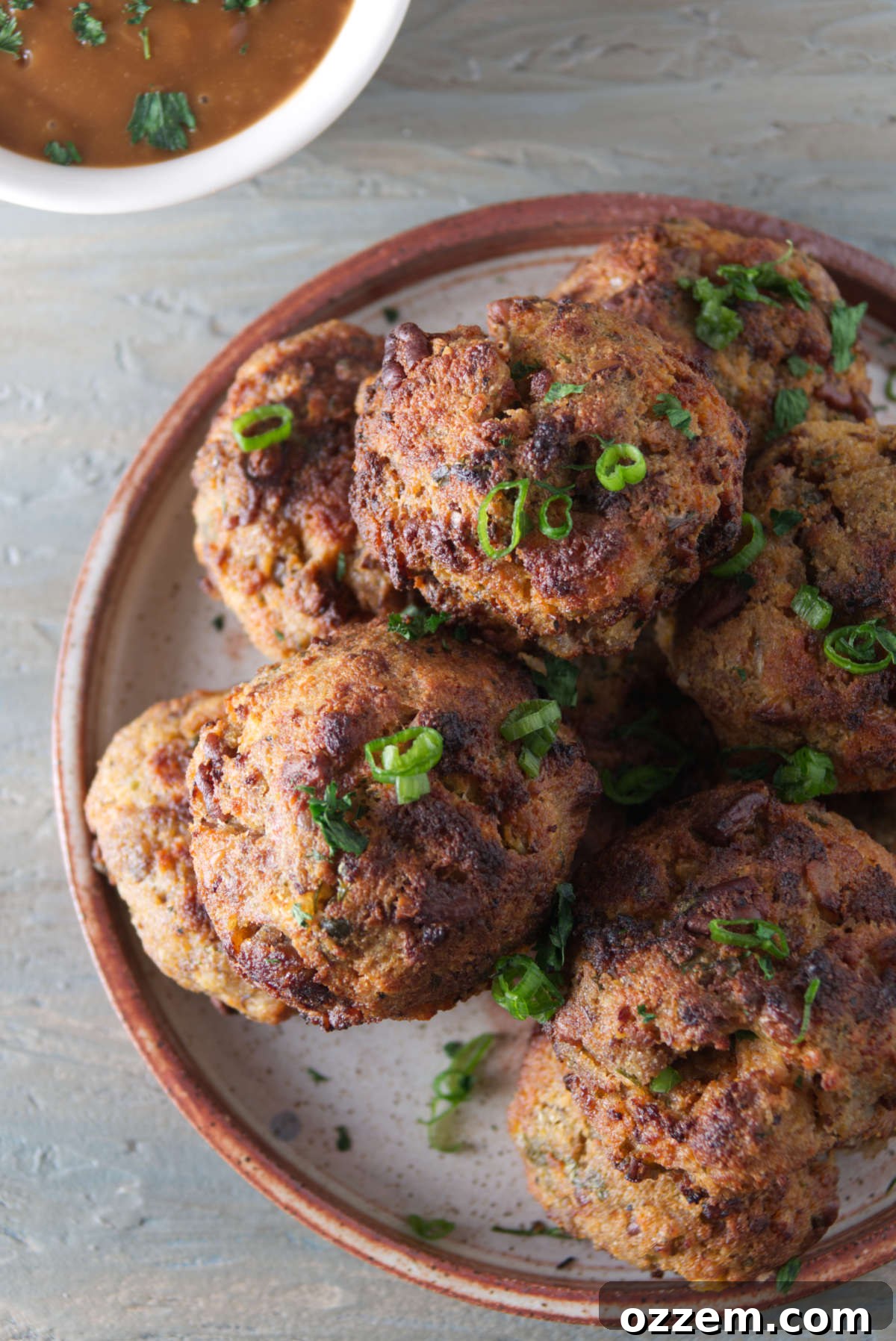 air fryer stuffing balls plated next to a bowl of gravy, ready to be served