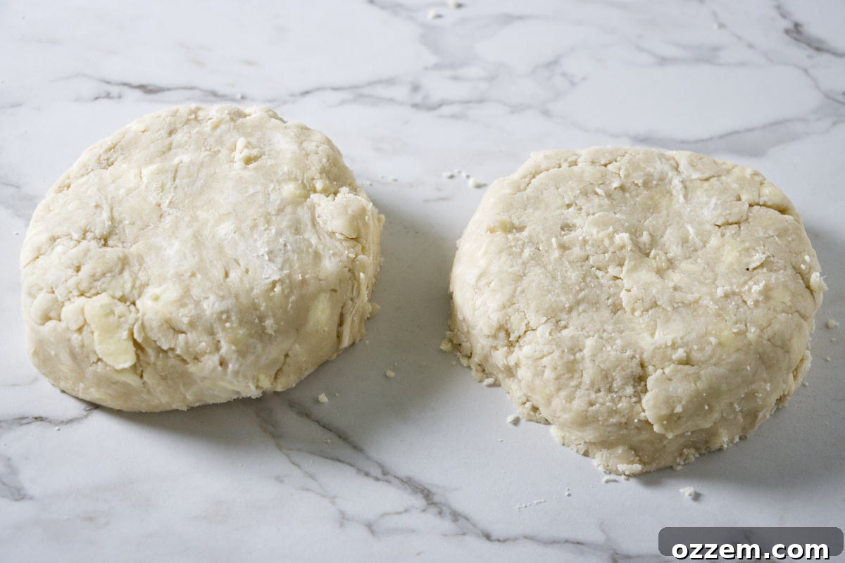 Dividing and shaping pie dough into two flattened disks, ready for chilling.