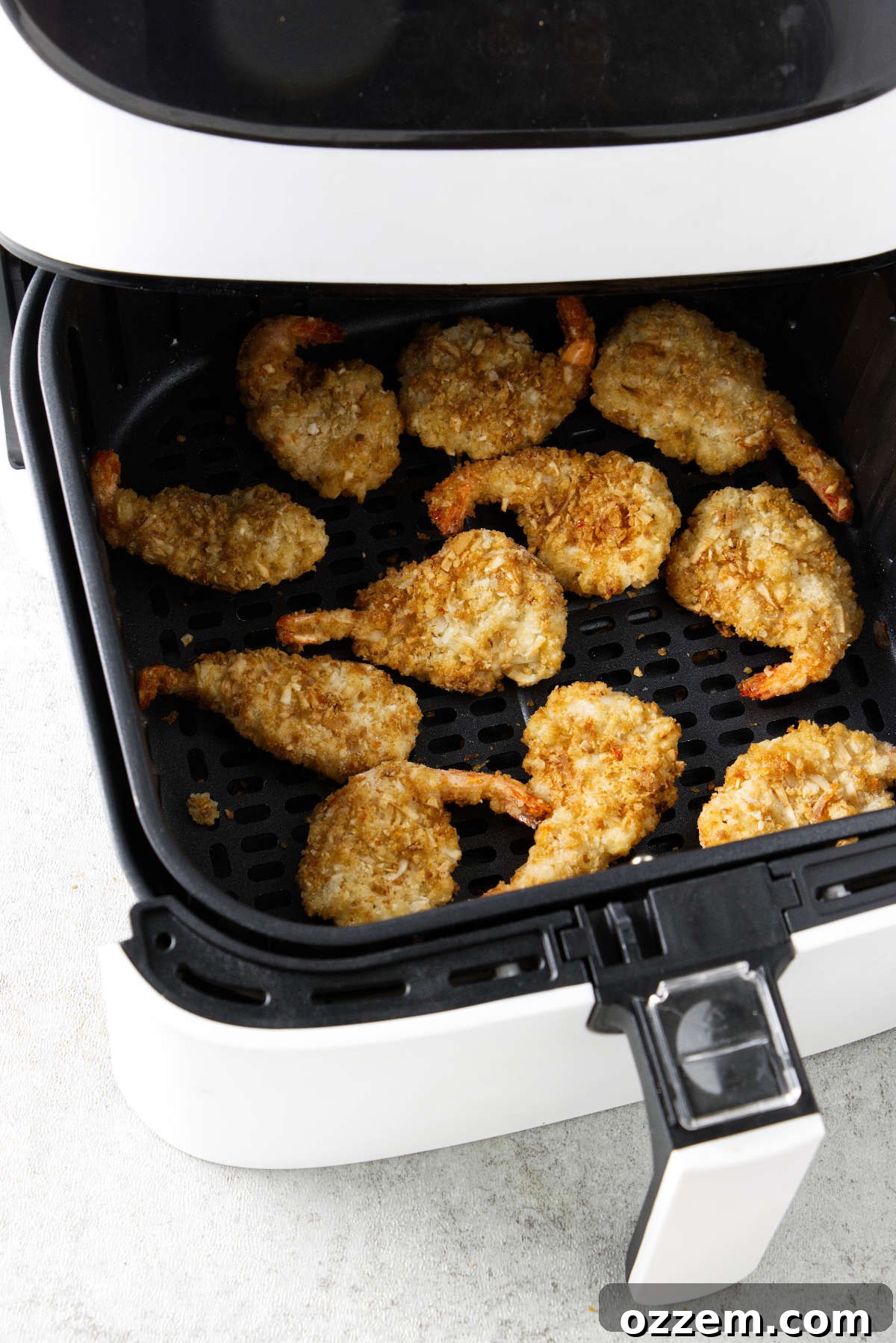 Crispy Air Fryer Frozen Coconut Shrimp 5 Breaded shrimp cooking in an air fryer.