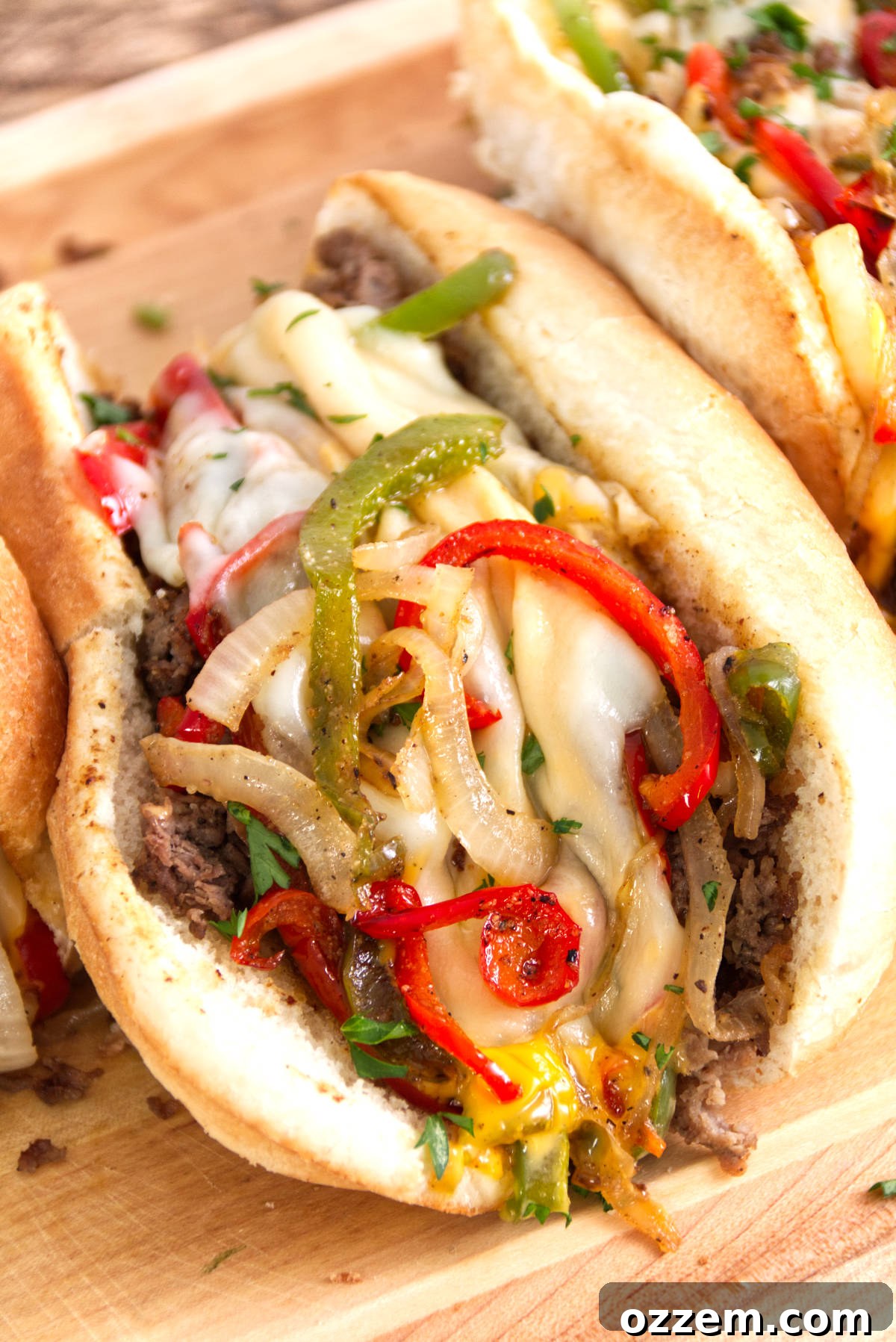 Sizzling Griddle Philly Cheesesteak 11 A close-up, irresistible photo of a perfectly assembled Philly cheesesteak, generously loaded with thinly sliced steak, vibrant red and green bell peppers, a cascade of gooey Cheese Whiz, and melted provolone cheese.