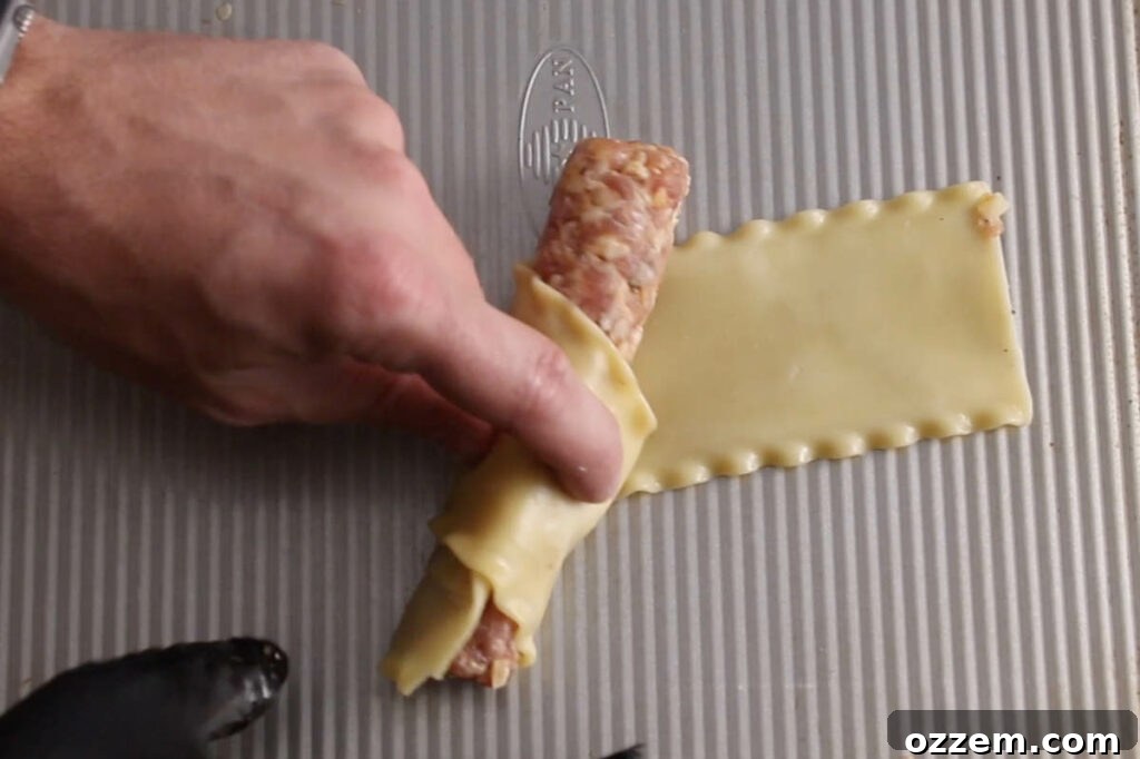 rolling lasagna noodle around sausage