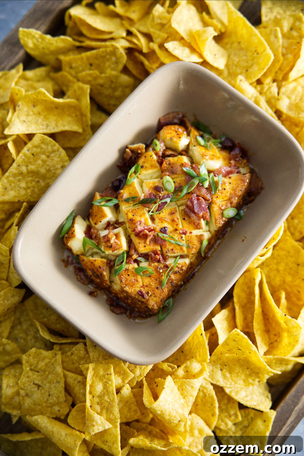Decadent Smoked Cream Cheese 2 smoked cream cheese in dish surrounded by chips and topped with bacon and scallions