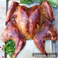Smoked spatchcock turkey on baking sheet ready to be carved