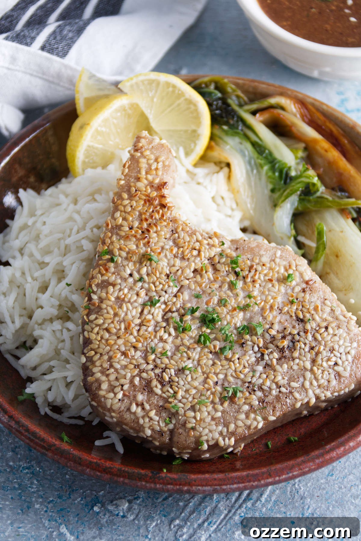 Succulent Air Fryer Tuna Steaks 2 sesame crusted whole ahi tuna steaks plated on a bed of rice