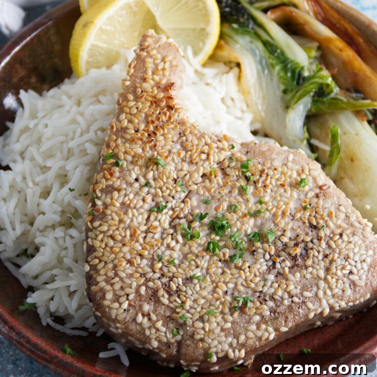 sesame crusted whole ahi tuna steaks plated on a bed of rice