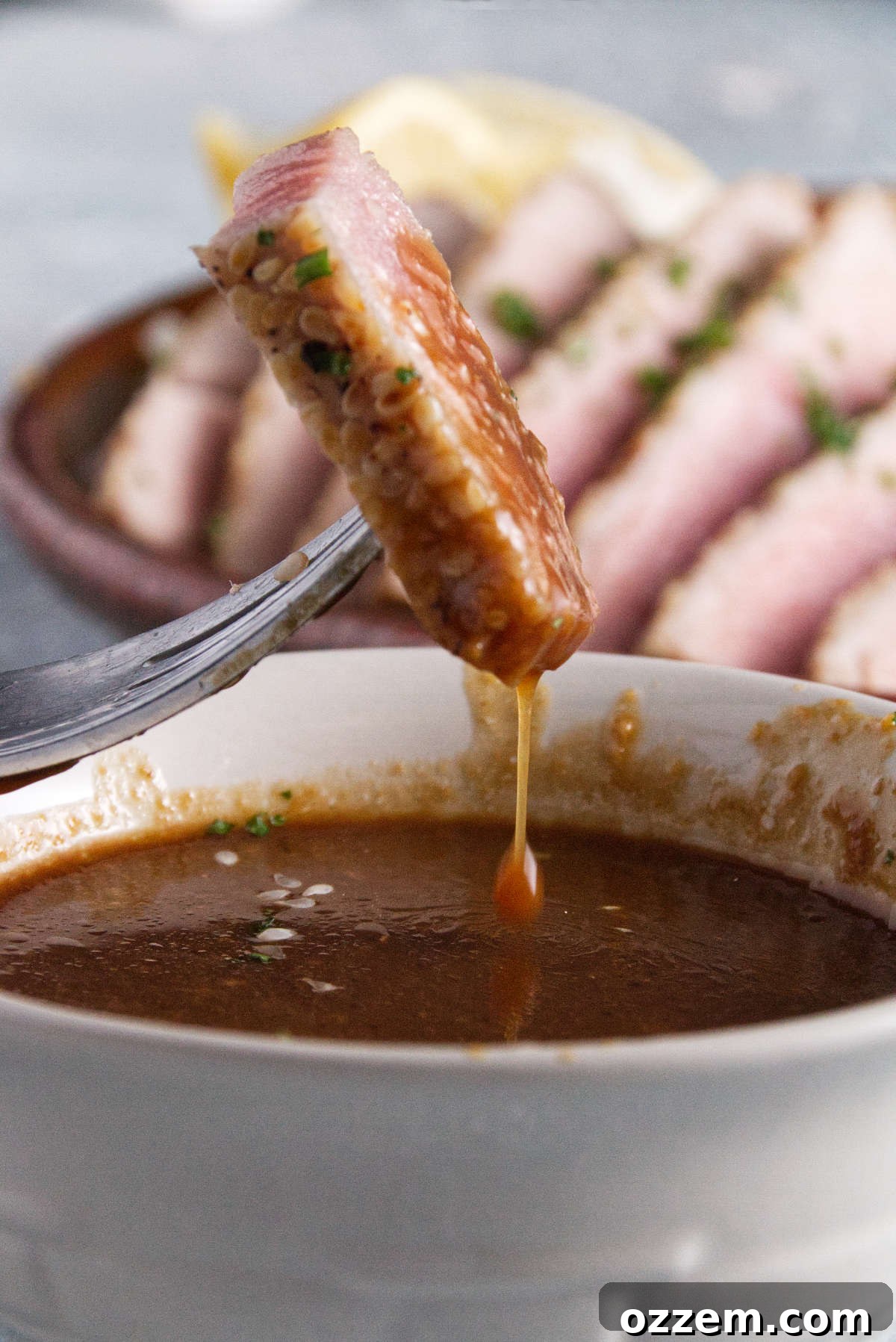 Succulent Air Fryer Tuna Steaks 9 dipping a slice of tuna steak in sauce