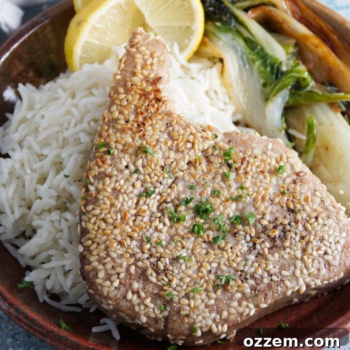 sesame crusted whole ahi tuna steaks plated on a bed of rice