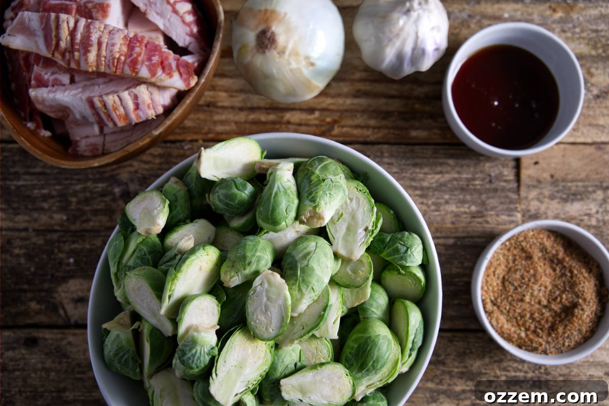 All the ingredients for smoked Brussels sprouts laid out on a wooden board: sprouts, bacon, onion, garlic, seasoning, and hot honey.