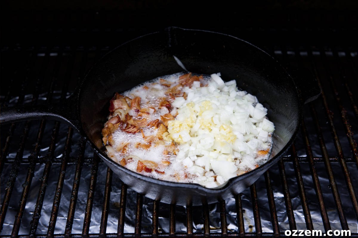 Bacon, onions, and garlic cooking together in a cast iron skillet